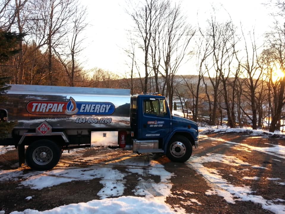 Tirpak Energy oil truck on a snowy hillside at sunset